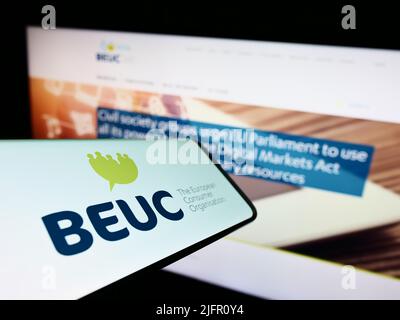 Smartphone con logo di Bureau Europeen des Unions de Consommateurs (BEUC) sullo schermo di fronte al sito web. Concentratevi sul centro-destra del display del telefono. Foto Stock