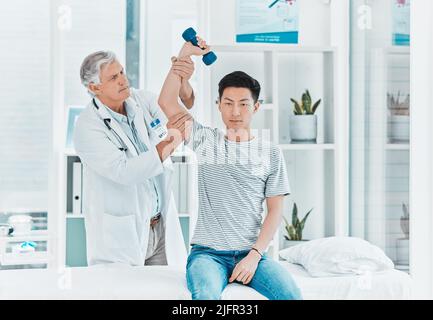 HES lavorava sulla sua forza. Shot di un medico maturo che verifica la forza dei suoi pazienti. Foto Stock
