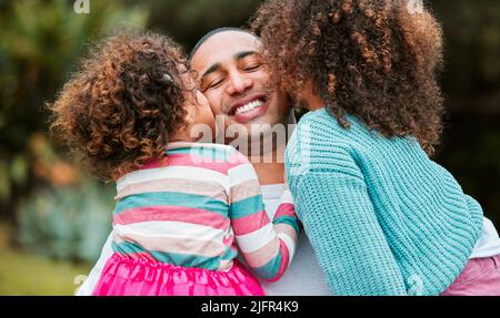 Essere un papà è la sensazione migliore nel mondo. Fucilata di due bambine che baciavano il padre sulla guancia. Foto Stock