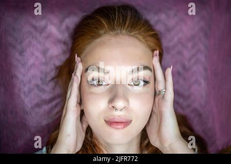 Giovane donna con belle sopracciglia dopo procedura permanente make-up in salone Foto Stock