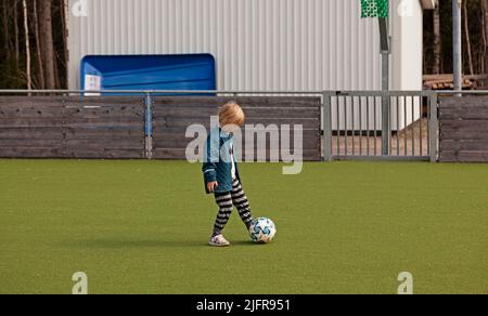 Umea, Norrland Svezia - 20 maggio 2022: Piccolo ragazzo gioca a calcio Foto Stock