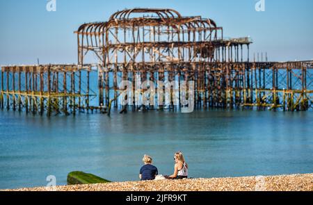 Brighton UK 5th Luglio 2022 - tempo di sedersi sulla spiaggia presso il West Pier a Brighton in una bella mattinata di sole come il tempo caldo è previsto per la Gran Bretagna nei prossimi giorni : Credit Simon Dack / Alamy Live News Foto Stock