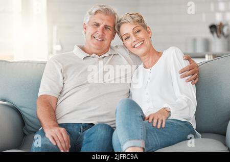 Sono stati sicuramente due di un genere. Scatto di una coppia anziana felice che si rilassa sul divano a casa. Foto Stock