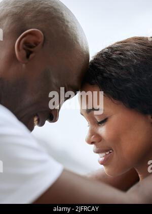 Primo piano di una felice giovane coppia afroamericana che si posa con la fronte insieme. Uomo e donna neri sorridenti e innamorati. Colpo di testa di Foto Stock