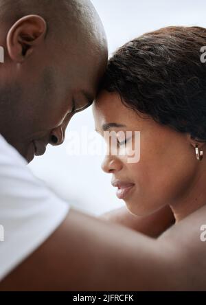 Primo piano di una giovane coppia sposata afroamericana in piedi faccia a faccia con la fronte che si toccano insieme. Uomo e donna neri in un amore Foto Stock