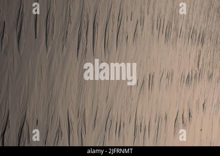 Motivi sulla spiaggia bagnata sabbia. Sabbia Sharp alla spiaggia Foto Stock