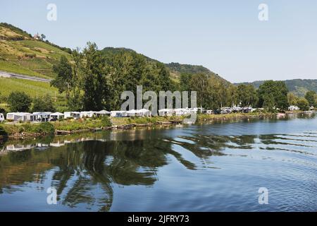 Campeggio, campeggio selvaggio in tende e roulotte sulle rive del Reno in Germania. Le tende si riflettono nell'acqua. Foto Stock