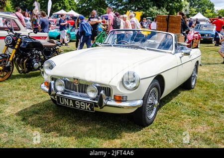 Vista frontale di un MGB 1971 bianco con un cestino da picnic attaccato al portabagagli posteriore al Berkshire Motor Show di Reading, Regno Unito Foto Stock
