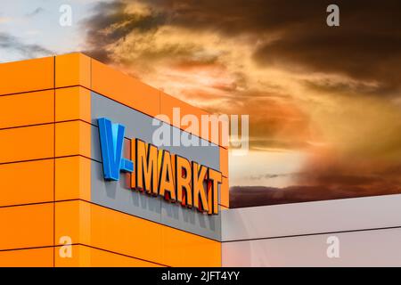 Werbe- und Firmanschild der Firma V-Markt am Eingang zum Markt Foto Stock