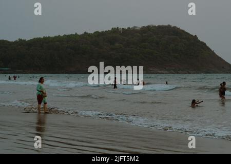 Sharavati River, Karnataka, India - Aprile 03,2022:folla che gioca in spiaggia in Waves.Woman camminare sulla spiaggia. Foto Stock