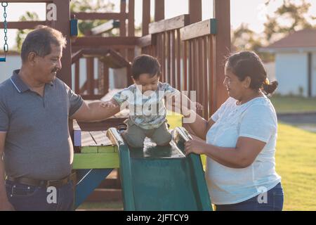 nonni che giocano con il nipote nel parco Foto Stock