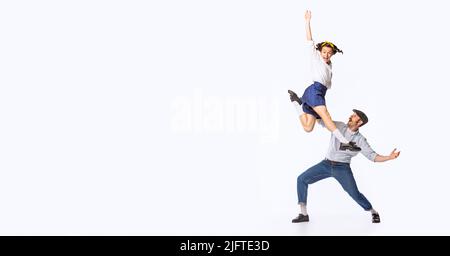 Ritratto di bella coppia, uomo e donna, danzante swing, rock o lindy hop isolato su sfondo bianco studio. Volantino Foto Stock