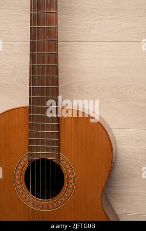 Corpo di chitarra classica in primo piano, su sfondo di legno chiaro con spazio di copia. Foto Stock