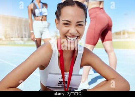 Ritratto closeup di donna atletica mista gara con una medaglia da competizione in eventi sportivi. Sorridente atleta attivo di latino che si sente orgoglioso dopo Foto Stock