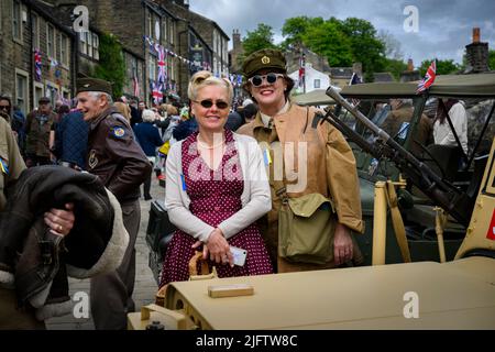 Haworth 1940 nostalgico evento di storia della vita retrò (Signore in abiti e occhiali da sole d'epoca WW2, affollata Main Street) - West Yorkshire, Inghilterra Regno Unito. Foto Stock