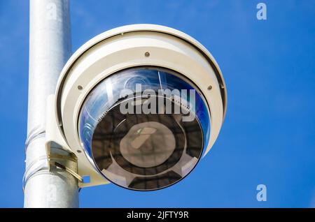 Un dispositivo di registrazione sulla strada. Videocamera sullo sfondo del cielo. Telecamera di sorveglianza in città. Foto Stock