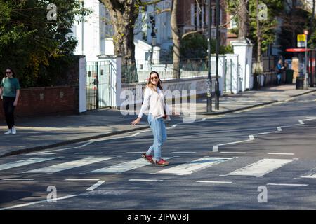 La gente cammina sulla zebra attraversando vicino Abbey Road Studios a Londra. Foto Stock