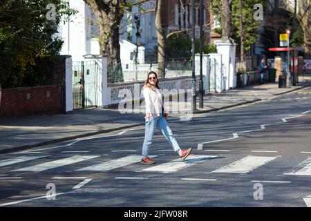 La gente cammina sulla zebra attraversando vicino Abbey Road Studios a Londra. Foto Stock