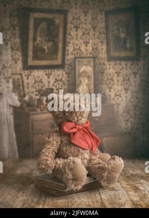 Un vecchio orsacchiotto di un bambino indossato seduto sopra un tavolo in un interno vintage Foto Stock