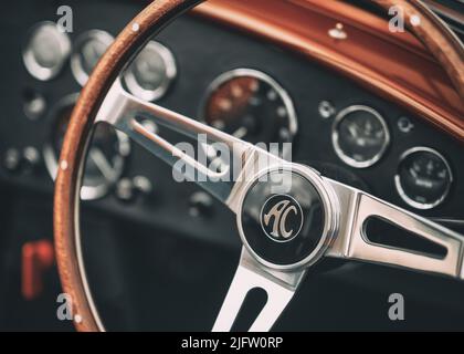 La sezione volante e cruscotto di una classica vettura sportiva AC Cobra rossa Foto Stock