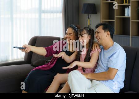Felice famiglia asiatica con padre, madre e figlia godere di attività week-end trascorrere più tempo a casa e quindi probabilmente più tempo di fronte al Foto Stock