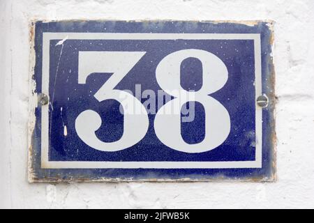 Numero 38 (trentotto) in bianco su una piastra di metallo blu Foto Stock