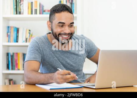 Videochiamata di un hipster latino-americano in ufficio Foto Stock