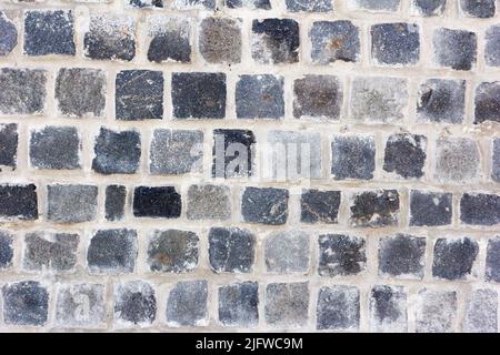 Un muro di fatto di mattoni grigi Foto Stock