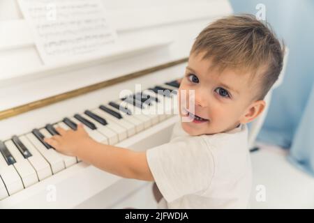 Piccolo ragazzo caucasico che suona il pianoforte, medio primo piano. Foto di alta qualità Foto Stock