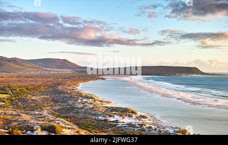 Paesaggio marino, paesaggio, vista panoramica di Hout Bay a Città del Capo, Sud Africa all'alba. Blu oceano e mare con montani al mattino. Viaggio in spiaggia Foto Stock