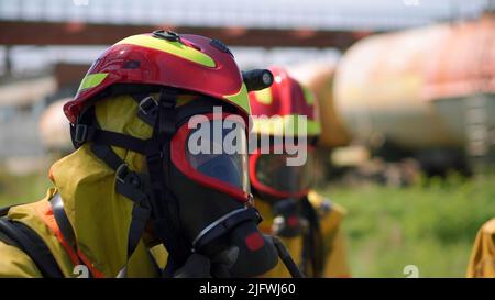 Vigili del fuoco. Clip. Due uomini mascherati che svolgono esercizi con un tubo e acqua con attrezzature speciali e in una speciale uniforme. FullHD di alta qualità Foto Stock