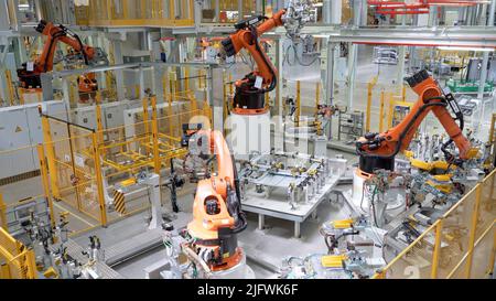 Russia, Mosca - 7 maggio 2022: Impianto automatizzato con robotica e lavoratori. Scena. Molte macchine robotizzate creano parti di automobili in una fabbrica moderna. Camera moderna Foto Stock