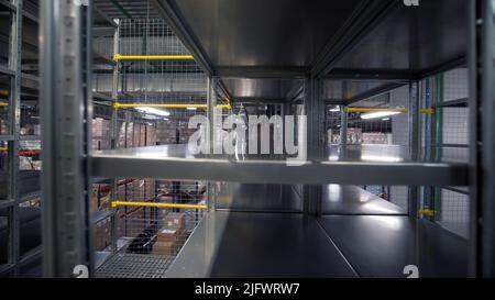 Storage.Creative.Un uomo che dispone scatole e utilizza veicoli speciali per la consegna. Riprese a 4K° di alta qualità Foto Stock