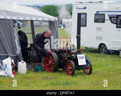 Uomo che espone il suo modello in scala da 4 pollici Foster motore di trazione agricolo al Launceston Steam & Vintage Rally, Cornovaglia, Regno Unito Foto Stock