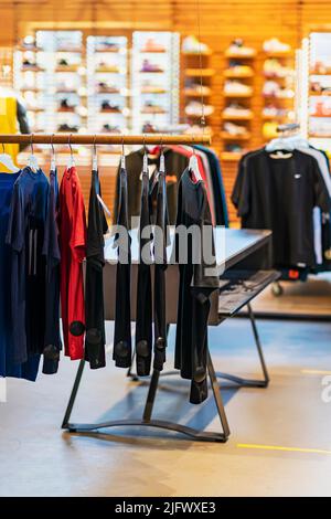 Abbigliamento su appendiabiti, vendita in negozio, abbigliamento per giovani e calzature in negozio di abbigliamento e calzature, focus selettivo Foto Stock