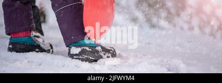 Scarpe invernali nella neve. Primo piano delle scarpe invernali. Scarpe impermeabili per bambini per camminare sulla neve. Temperature basse e caduta della neve Foto Stock