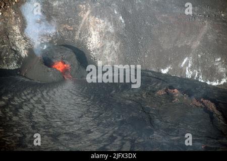 Una vista della bocca occidentale che fornisce la lava al lago di lava a Halema'uma'u, alla cima di K?lauea, Hawaii. In basso a destra, il complesso di fessura occidentale dell'eruzione del 2020ÐMay dicembre 2021 è visibile come una caratteristica spiny e noioso marrone scuro e rosso. La vecchia fessura è stata sollevata dall'attuale lago di lava, e sembra galleggiare sulla superficie (simile a come un iceberg galleggia nell'oceano). Questa foto è stata scattata durante un volo in elicottero dell'Osservatorio del Vulcano Hawaiiano il 15 ottobre 2021. Credit N. Deligne/USGS Foto Stock