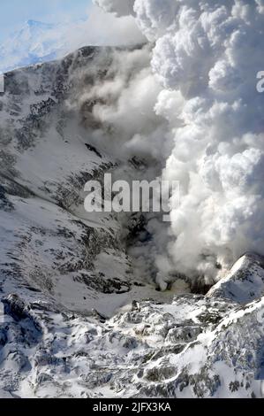 Il cratere della cima del vulcano Redoubt durante l'eruzione. Il Monte Redoubt è un stratovulcano attivo nella regione di Aleutian, Alaska, Stati Uniti d'America.. Questo è stato preso subito dopo la cessazione dell'attività esplosiva a rimessa in dubbio. Le emissioni di gas e vapore sono ancora significative. Il vulcano Iliamna a sud di Redoubt è visibile sullo sfondo. Credito: C.Read/USGS Foto Stock