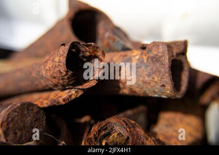 Diversi vecchi rottami di metallo arrugginito da diversi articoli primo piano. Raccolta e consegna di rottami metallici. Sfondo astratto. Messa a fuoco morbida, sfocatura. Foto Stock