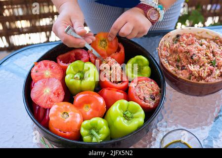 Cucina greca tradizionale Gemista già cotto nel forno. Peperoni ripieni, pomodori, zucchine con riso, verdure, erbe e talvolta carne tritata Foto Stock