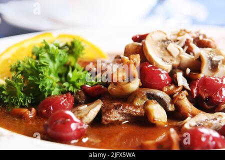 Specialità gastronomiche tedesche: Stufato di cinghiale con funghi e ciliegia Foto Stock