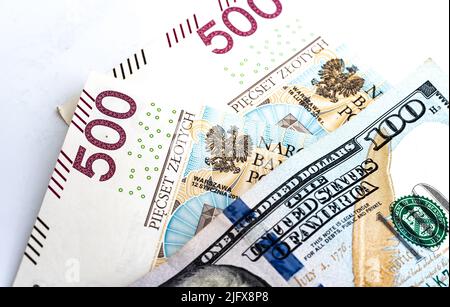 Banconote in denaro, banconote in dollari statunitensi e zloty polacche sparse su sfondo bianco. Tassi di cambio da PLN a USD. Versamento di denaro. Foto Stock