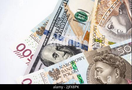 Banconote in denaro, banconote in dollari statunitensi e zloty polacche sparse su sfondo bianco. Tassi di cambio da PLN a USD. Versamento di denaro. Foto Stock