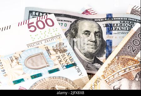 Banconote in denaro, banconote in dollari statunitensi e zloty polacche sparse su sfondo bianco. Tassi di cambio da PLN a USD. Versamento di denaro. Foto Stock