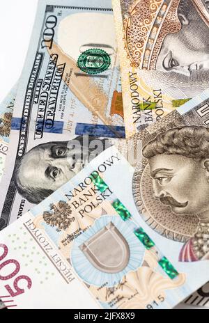 Banconote in denaro, banconote in dollari statunitensi e zloty polacche sparse su sfondo bianco. Tassi di cambio da PLN a USD. Versamento di denaro. Foto Stock