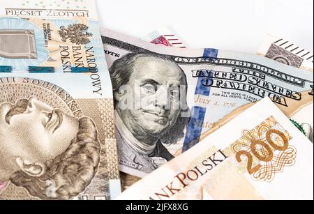 Banconote in denaro, banconote in dollari statunitensi e zloty polacche sparse su sfondo bianco. Tassi di cambio da PLN a USD. Versamento di denaro. Foto Stock