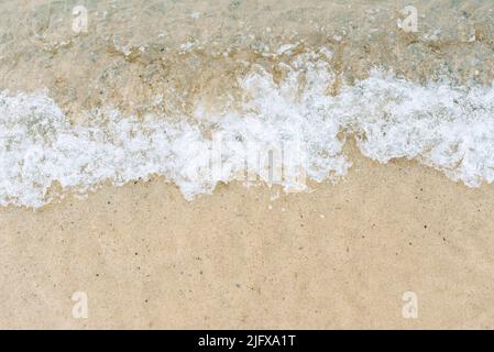 Primo piano di lavaggio delle onde sulla spiaggia di sabbia Foto Stock