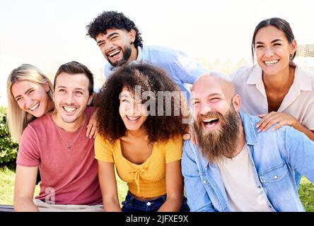 Gruppo allegro di amici in posa per una foto e divertirsi. Amicizia e concetto di comunità Foto Stock