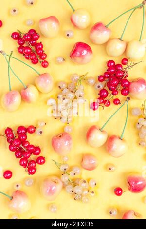 Ribes giallo e rosso con ciliegie gialle su sfondo giallo Foto Stock