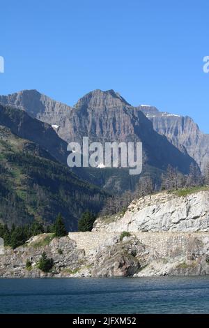 Glacier scolpito lago e colorata cintura serie rocce sedimentarie di Mahtotopa e Little Chief Mountains, cielo blu brillante, Glacier National Park, MT, Stati Uniti Foto Stock